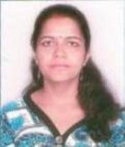 Portrait of Dr. Kapoor wearing traditional attire with academic books in background